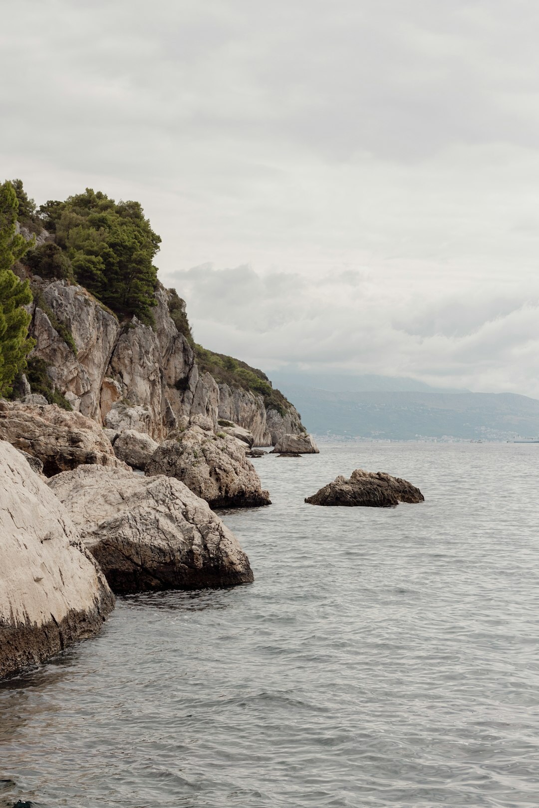 Dramatic rocky Adriatic coastline during a storm with dark clouds and crashing waves